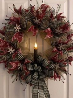 a christmas wreath with a lit candle on the front door