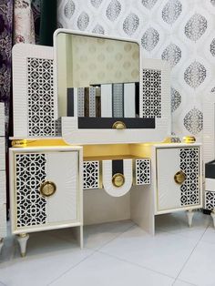 a white and gold vanity with mirrors on it