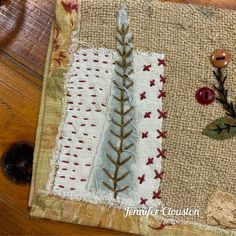 a close up of a piece of fabric on a wooden floor with buttons and thread