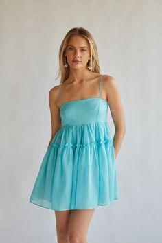 Giving angel energy in the Noah Organza Babydoll Mini Dress! This stunning dress is made of a shimmering organza material and features a straight across neckline, adjustable spaghetti straps, babydoll silhouette, smocked back, and a tiered ruffle detail.  to finish off the look!Details100% PolyesterLining: 97% Polyester, 3% SpandexFully linedSlip onSilicone gripHand wash cold / Hang dry Homecoming Dresses Babydoll, Hoco Dresses With Straps, Homecoming 2024, Organza Material, Blue Babydoll Dress, Red Floral Top, Angel Energy, Blue Organza, Straight Across Neckline