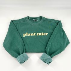 "This comfy, heavyweight vegan activism crewneck sweatshirt features our \"Plant Eater\" graphic on the front and is blank on the back. Material: 80% ringspun cotton, 20% polyester that is preshrunk, soft-washed, and made from garment-dyed fabric. Fit: Unisex. Make sure to check the size chart (swipe through photos). Care: Wash inside out and tumble dry low or hang dry. Do not iron or dry clean." Organic Relaxed Fit Crew Neck Tops, Organic Cotton Crew Neck Tops, Long Sleeve Organic Cotton Tops For Streetwear, Casual Organic Cotton Sweatshirt With Letter Print, Organic Cotton Crew Neck Sweatshirt For Streetwear, Relaxed Fit Organic Cotton Crew Neck Sweater, Organic Cotton Long Sleeve Sweatshirt With Letter Print, Organic Cotton Sweatshirt For Winter Streetwear, Green Sweatshirt For Streetwear