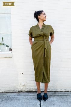 a woman standing in front of a white brick wall with her hands on her hips