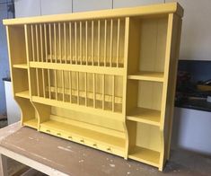 a yellow bookcase sitting on top of a wooden table