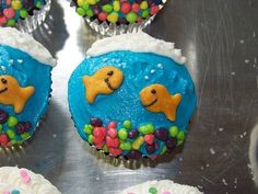 cupcakes decorated with blue frosting and sprinkles on a silver surface