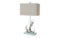 a lamp that is sitting on top of a white base with a beige shade over it