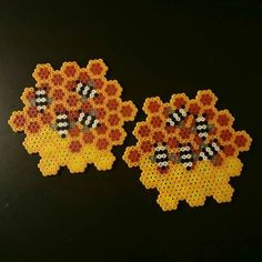 two pieces of beaded art made to look like flowers with bees on them, sitting next to each other