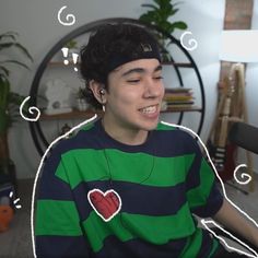 a young man sitting in front of a microphone wearing a green and blue striped shirt