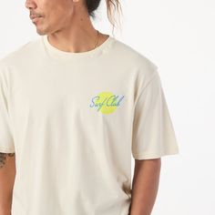 Gear up for sunset sessions and morning paddleouts this summer with our Surf Club Tee. Crafted from 100% cotton, it's your go-to for beach days and beyond. With our Surf Club logo on the front, it's the perfect summer uniform for embracing those laid-back moments by the waves. | Surf Club T-shirt in Natural Surf Club | Size: XL | by ALOHA Collection Summer Cotton Tops With Back Print, Relaxed Fit T-shirt With Back Print For Summer, Cotton Tops With Back Print For Summer, Sporty Summer Tops With Back Print, Sporty Tops With Back Print For Summer, Summer Cotton T-shirt For Surfing, Relaxed Summer Tops With Screen Print, Cotton Beach Top With Back Print, Cotton Top With Back Print For Beach