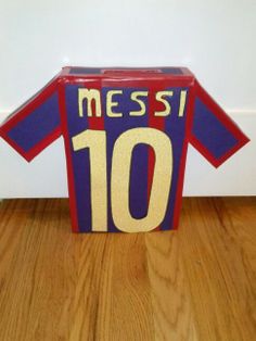 a cardboard messi shirt sitting on top of a wooden floor