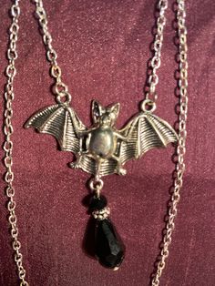 Bat and black gem necklace silver effect Black Vampire Pendant Jewelry, Black Vampire Style Pendant Jewelry, Black Gothic Metal Necklace, Silver Vampire Style Necklace, Gothic Black Necklace With Silver Chain, Gothic Pendant Necklace With Silver Chain, Gothic Silver Necklace With Clavicle Chain, Silver Vampire Style Metal Jewelry, Silver Gothic Clavicle Chain Necklace