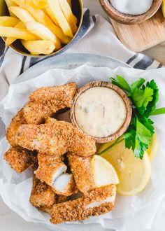 chicken tenders on a plate with lemon wedges and parsley