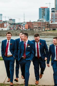 a group of men in suits and ties walking down a sidewalk next to each other