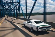 a white car driving down a highway next to a bridge