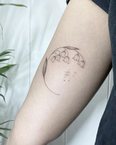 a woman's arm with a tattoo on it that has flowers growing out of it