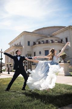 a man and woman are dancing in front of a large building with columns on it