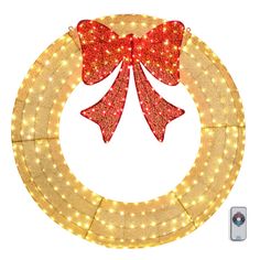 a lighted christmas wreath with red bows and lights on the front, sitting in front of a white background