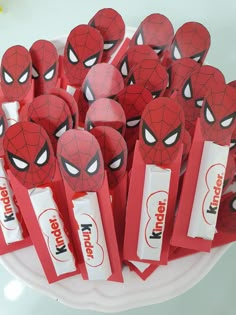 there are many spiderman candy sticks on the plate