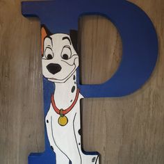 the letter d is made up of wood and has a cartoon dog on it's face