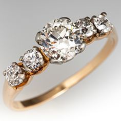 a three stone diamond ring with two diamonds on each side and four smaller stones in the middle