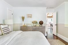 a bedroom with white walls and wood floors