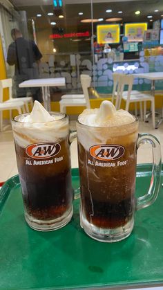 two mugs filled with ice cream sit on a green tray