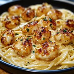 pasta with shrimp and parmesan cheese in a black bowl on a wooden table