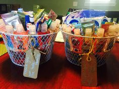 two baskets filled with baby items sitting on top of a table