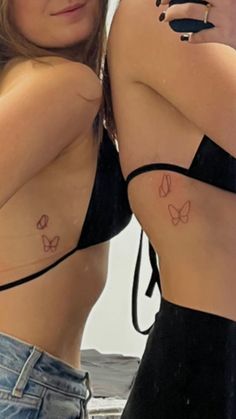 two women with butterfly tattoos on their chests, one is taking a selfie