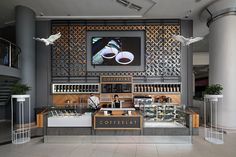 a coffee shop with two birds flying over the counter and on the wall above it