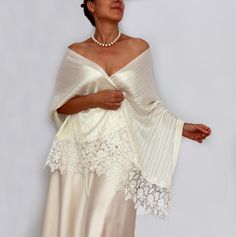 This elegant one-of-a-kind ivory bridal shawl is subtly enhanced with slight silver threading, adding a delicate shimmer to its design. Measuring 59.1" in length (150 cm, excluding the wide lace trims) and 21.7" (55 cm) in width, it drapes gracefully over the upper body. The combination of shimmery fine satin fabric and generous guipure lace trims makes it an ideal, refined accessory for any bride.  *It's suitable for those with an upper body circumference, including the chest and arms, up to 46.1" (117 cm).* **For reference, the model pictured is wearing a size S/M with a body circumference of 40.6" (103 cm).** For more similar wedding & evening cover-ups, please kindly visit https://www.etsy.com/shop/mammamiabridal?section_id=11494946 https://www.etsy.com/shop/mammamiaeme?section_id=1848 Elegant White Evening Veil, Elegant Cream Shawl For Evening, Fitted Shawl For Mother Of The Bride, Elegant White Evening Shawl, Cream Silk Shawl For Wedding, Cream Shawl For Evening, Cream Pashmina Shawl For Wedding, Elegant Silk Shawl For Weddings, Elegant Satin Shawl For Wedding