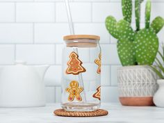 a glass jar with ginger cookies on it next to a potted cactus and cacti