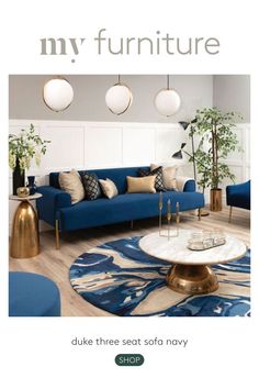 a living room filled with blue couches and gold accents on top of wooden floors