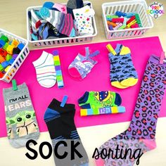 several pairs of socks sitting on top of a pink surface with the words sock sorting in front of them