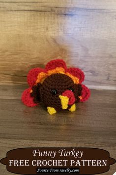 a small crocheted turkey sitting on top of a wooden floor next to a wall