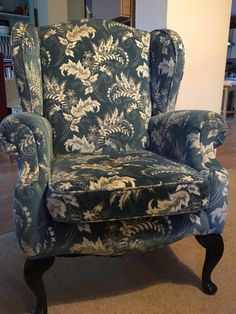 a blue and white chair sitting on top of a carpeted floor