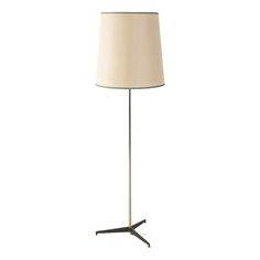 a floor lamp with a white shade on it's base and a black stand