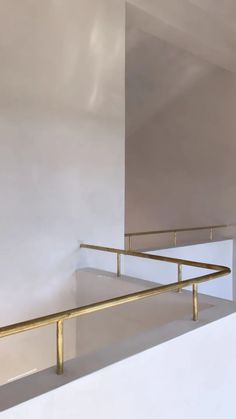 an empty room with white walls and gold railing