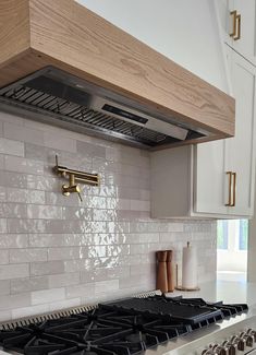 a stove top oven sitting inside of a kitchen next to white cabinets and counter tops