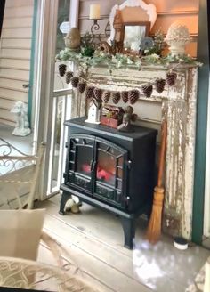 an old fashioned stove in front of a fireplace with pine cones on the mantel