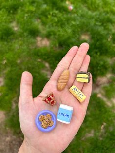 a person holding out their hand with small food items in the palm and on top of it