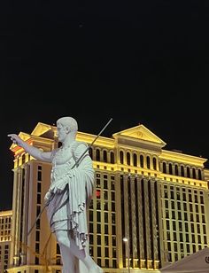 there is a statue in front of the las vegas hotel and casino tower at night