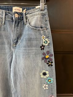 a pair of jeans with flowers painted on them