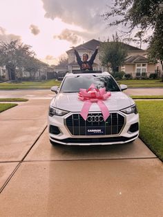 an audi car with a pink bow on the hood