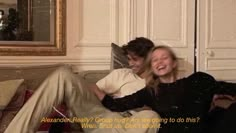 two people sitting on a couch laughing and hugging each other with the caption above them