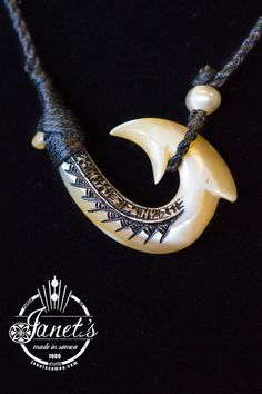 a necklace with an animal's head in the center and two pearls hanging from it