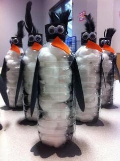 several penguins made out of plastic bottles with googly eyes