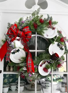 a christmas wreath is hung on the window sill in front of a china cabinet