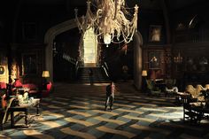 a person standing in a large room with chandelier