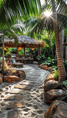 an outdoor dining area with palm trees and stone walkway leading to the pool at sunset