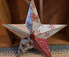 an origami star hanging from a wooden shelf